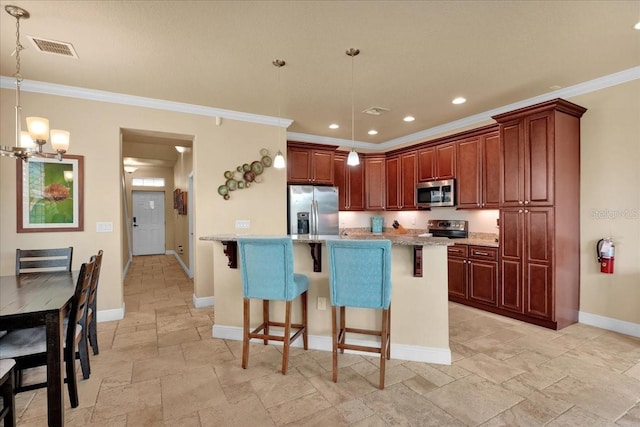 kitchen with pendant lighting, a center island with sink, a breakfast bar, and appliances with stainless steel finishes