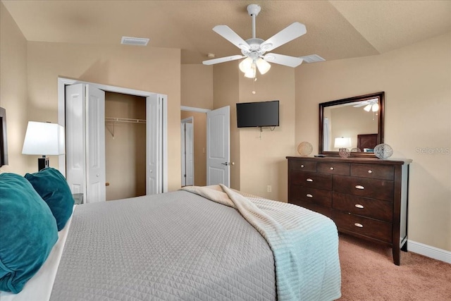 carpeted bedroom featuring vaulted ceiling, a closet, and ceiling fan