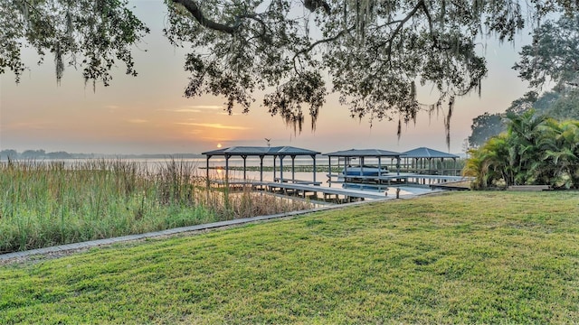 view of dock featuring a lawn