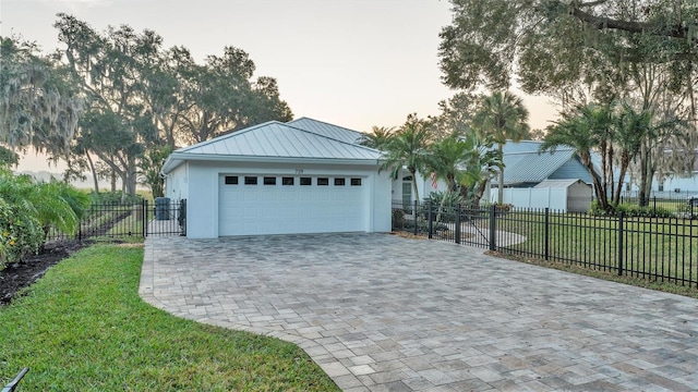 garage at dusk featuring a yard