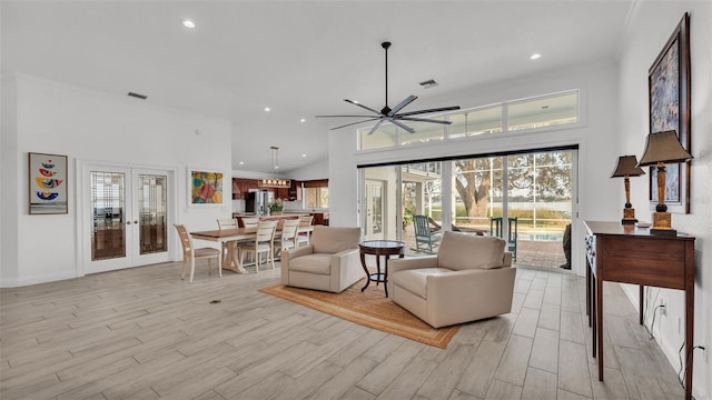 living room featuring ceiling fan, high vaulted ceiling, light wood-type flooring, and french doors