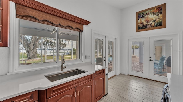 kitchen featuring sink, french doors, ceiling fan, and light wood-type flooring