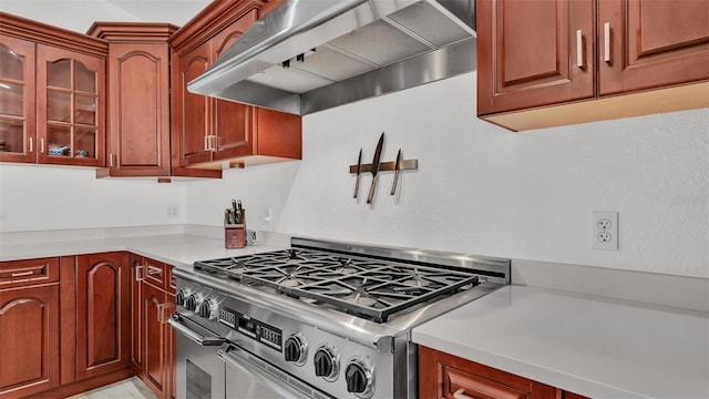 kitchen featuring range with two ovens and wall chimney exhaust hood