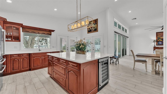 kitchen with sink, a center island, wine cooler, decorative light fixtures, and french doors