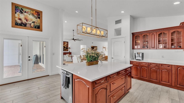 kitchen featuring a center island, ceiling fan with notable chandelier, and decorative light fixtures