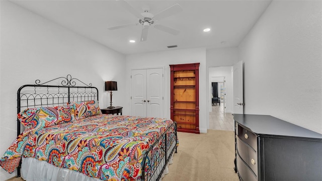 carpeted bedroom featuring ceiling fan and a closet