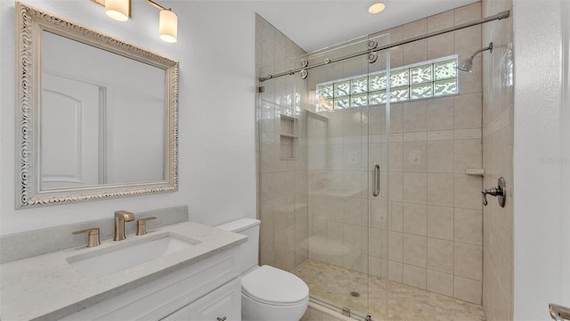 bathroom featuring vanity, toilet, and a shower with shower door