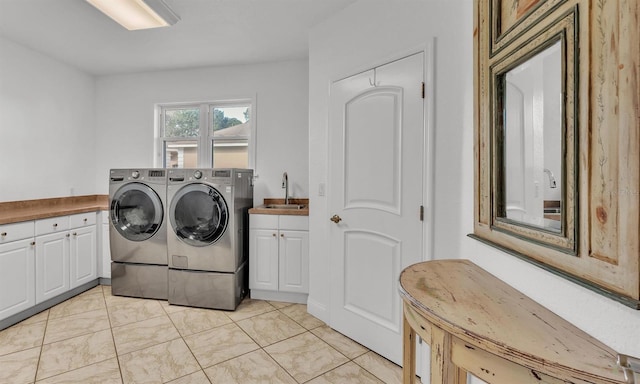 clothes washing area with cabinets, sink, and washer and clothes dryer