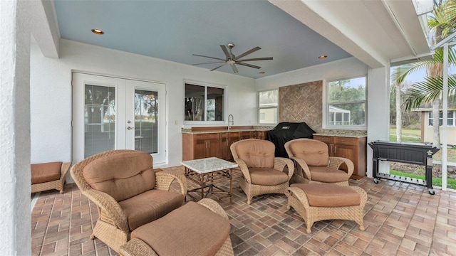 sunroom / solarium with sink, french doors, and ceiling fan