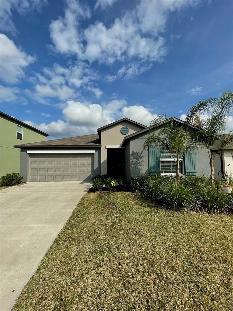 view of front facade with a garage and a front lawn