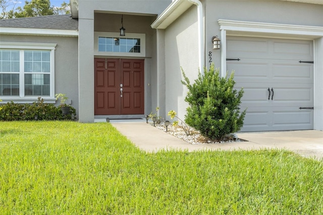 property entrance featuring a garage and a yard