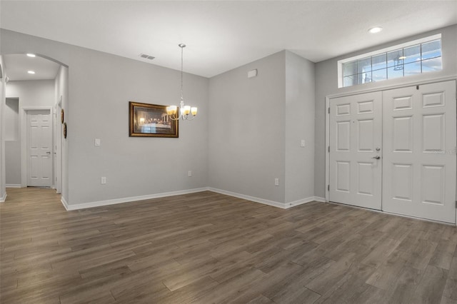 entrance foyer featuring an inviting chandelier and dark hardwood / wood-style floors