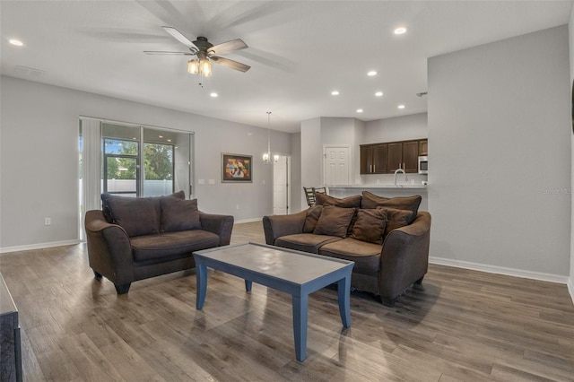 living room featuring sink, hardwood / wood-style flooring, and ceiling fan