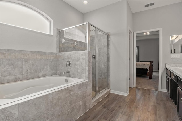 bathroom featuring independent shower and bath, vanity, and hardwood / wood-style floors