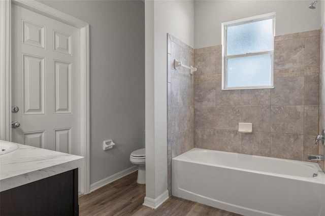 full bathroom with tiled shower / bath, wood-type flooring, toilet, and vanity