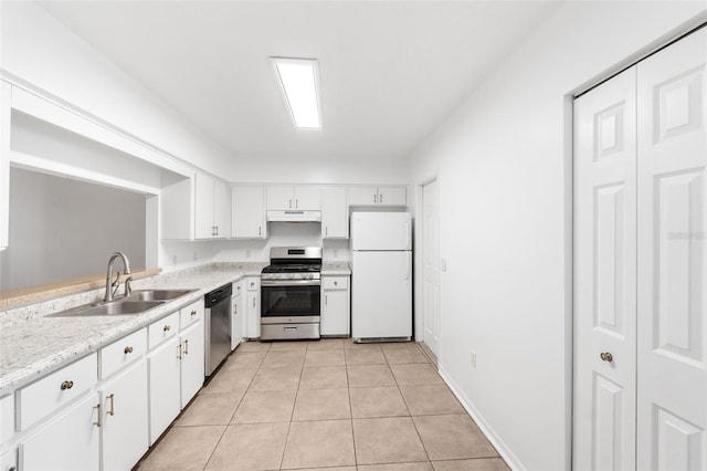 kitchen with light tile patterned flooring, sink, white cabinetry, light stone counters, and appliances with stainless steel finishes