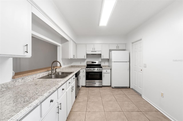 kitchen with sink, appliances with stainless steel finishes, white cabinetry, light stone counters, and light tile patterned flooring