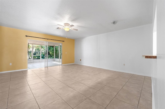 empty room with light tile patterned floors, a textured ceiling, and ceiling fan