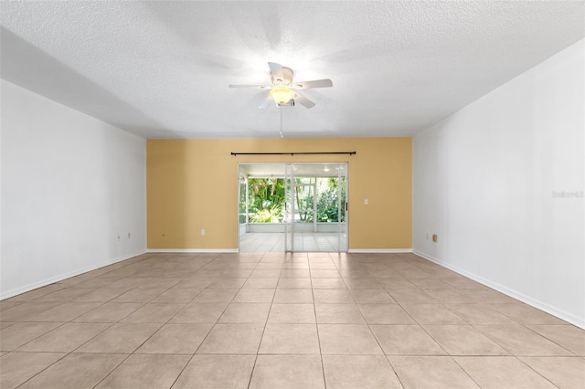 empty room featuring ceiling fan, a textured ceiling, and light tile patterned floors