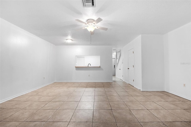 empty room with ceiling fan and a textured ceiling