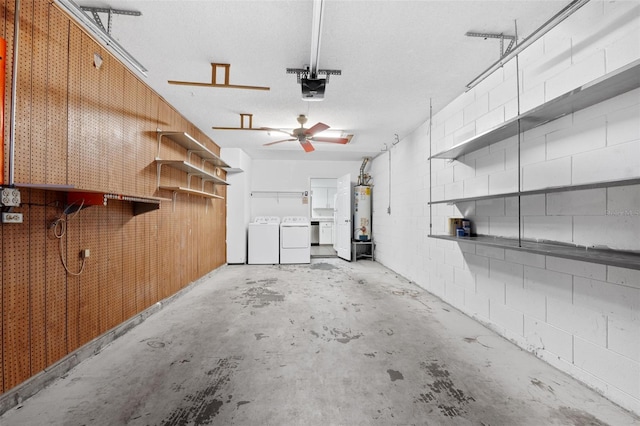 garage with a garage door opener, separate washer and dryer, and water heater