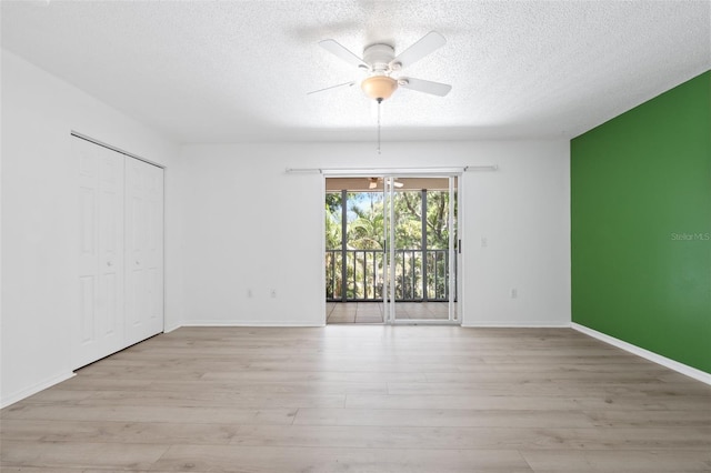 unfurnished room featuring ceiling fan, light hardwood / wood-style floors, and a textured ceiling