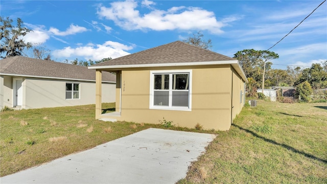 back of property with a yard and a patio