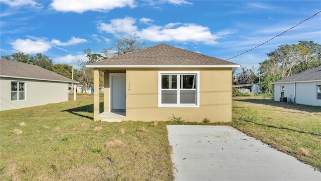 back of house featuring a yard, central AC, and a patio area