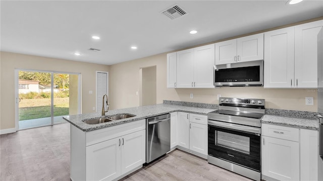 kitchen featuring sink, stainless steel appliances, kitchen peninsula, and white cabinets