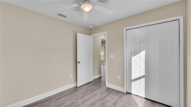 unfurnished bedroom featuring light hardwood / wood-style flooring, a closet, and ceiling fan