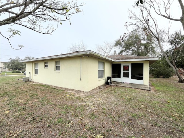 rear view of house with a yard and a sunroom