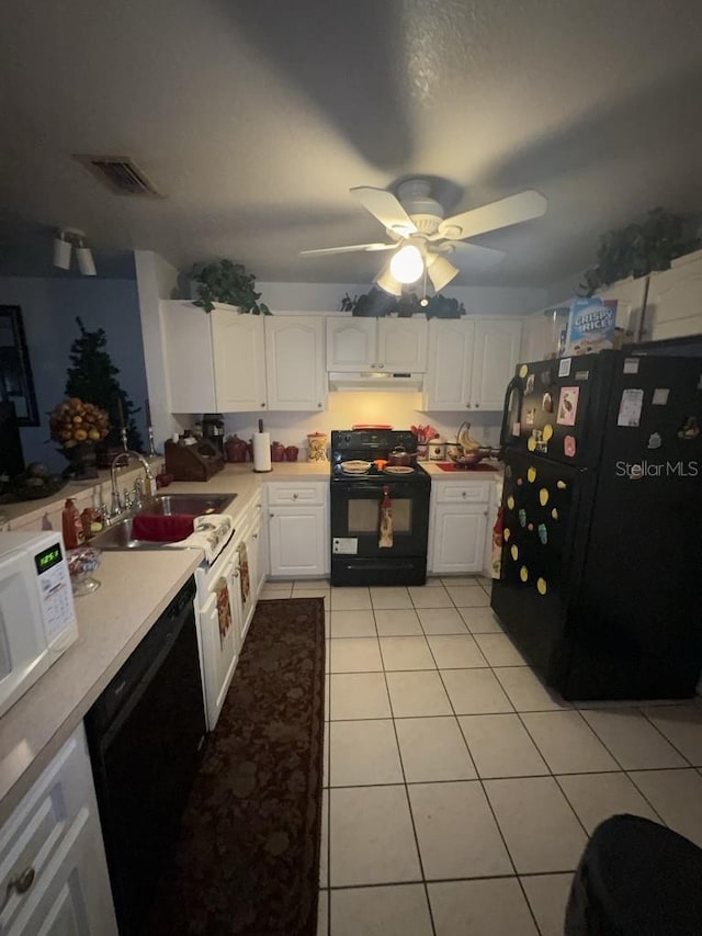 kitchen featuring white cabinetry, sink, light tile patterned floors, and black appliances