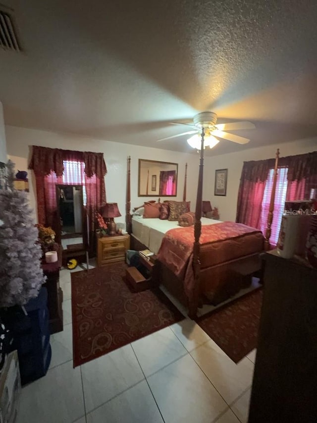 bedroom with ceiling fan and a textured ceiling