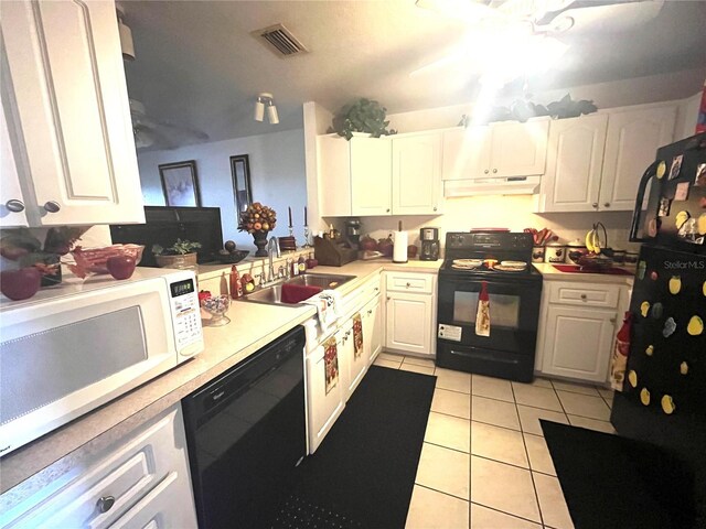 kitchen featuring sink, white cabinets, light tile patterned floors, and black appliances