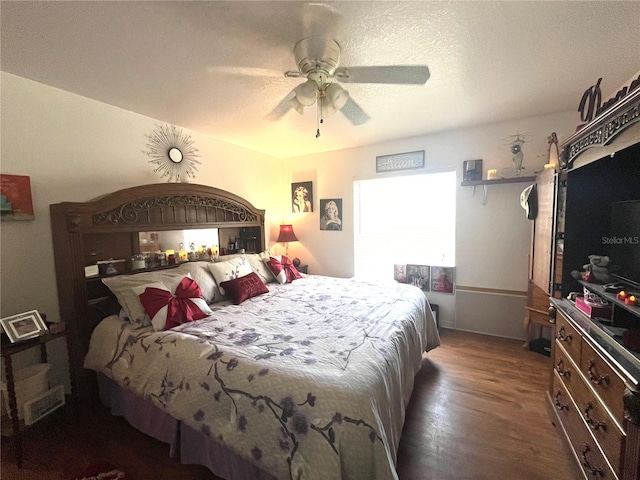 bedroom with a textured ceiling, dark hardwood / wood-style floors, and ceiling fan