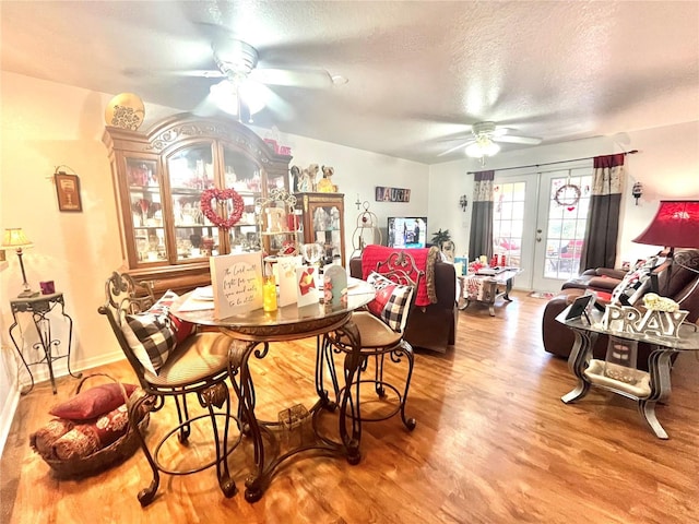 dining area featuring a textured ceiling, french doors, hardwood / wood-style flooring, and ceiling fan