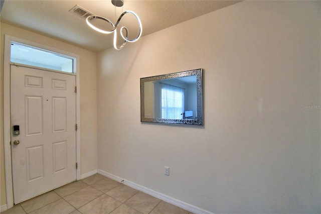 foyer with light tile patterned floors and a healthy amount of sunlight