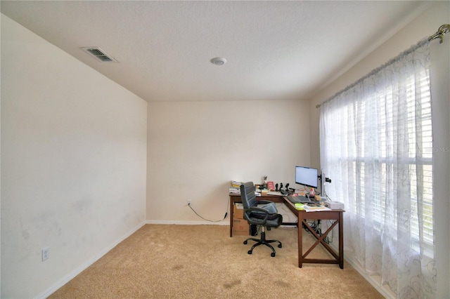 carpeted office featuring a textured ceiling