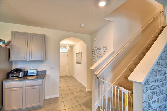 kitchen featuring gray cabinets, a textured ceiling, and light tile patterned flooring