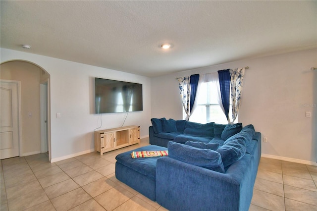 tiled living room featuring a textured ceiling