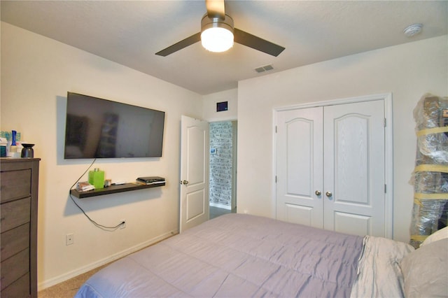 carpeted bedroom with ceiling fan and a closet