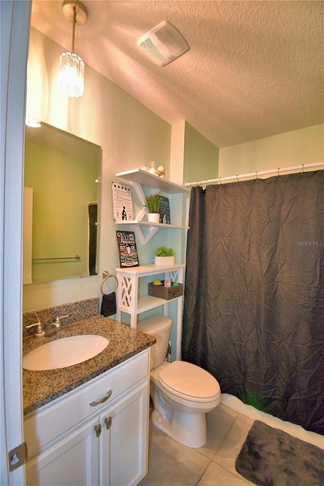 bathroom with tile patterned floors, toilet, a shower with curtain, a textured ceiling, and vanity