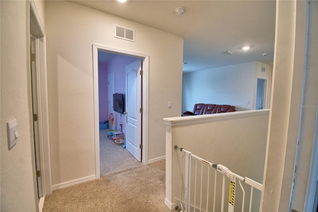 corridor featuring light colored carpet