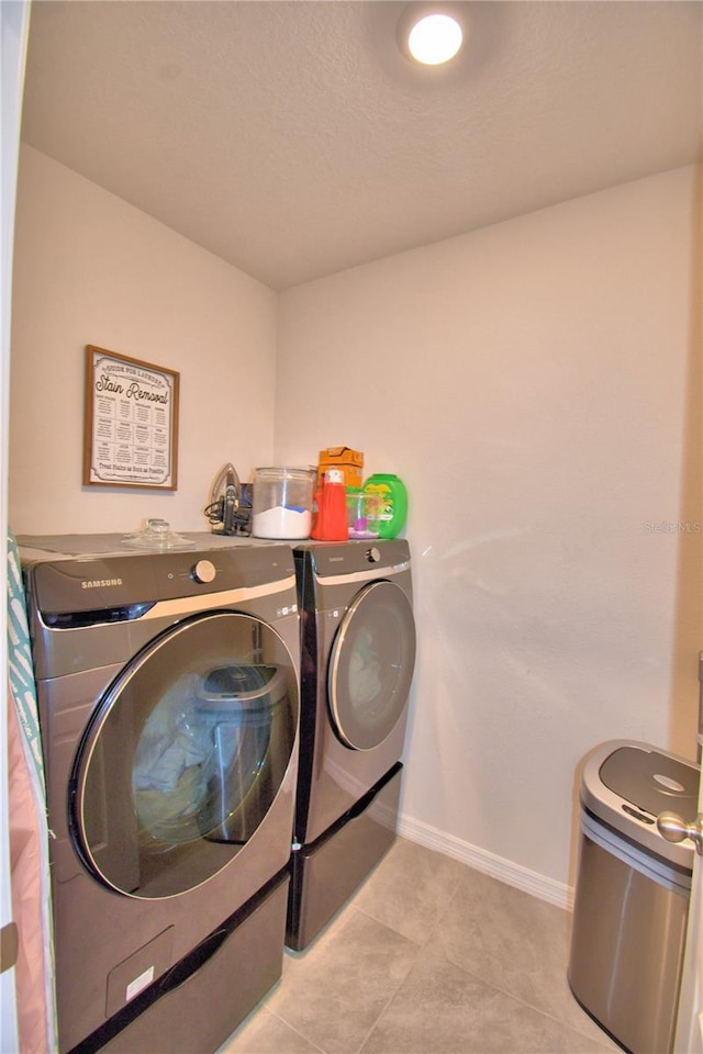 laundry area with light tile patterned flooring and washing machine and clothes dryer