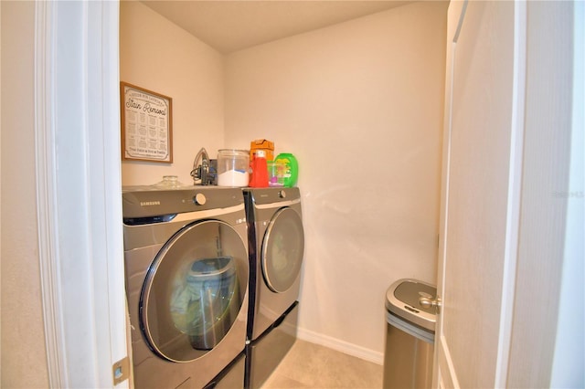 laundry area featuring light tile patterned floors and washing machine and clothes dryer