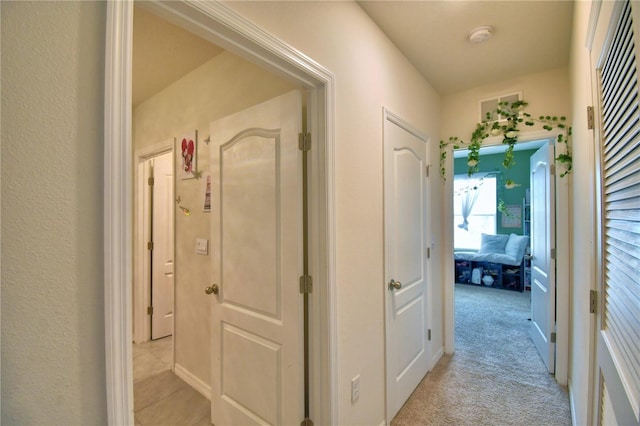 hallway featuring light colored carpet