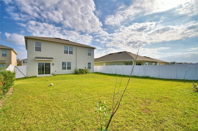 back of house featuring a lawn