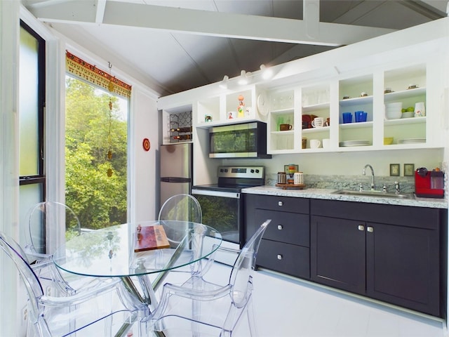 kitchen with appliances with stainless steel finishes, light stone countertops, and sink