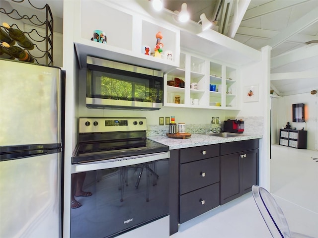 kitchen with sink, lofted ceiling with beams, stainless steel appliances, and light stone countertops