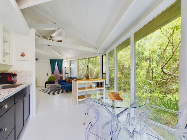 sunroom / solarium featuring vaulted ceiling, sink, and ceiling fan